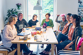 Eine inklusive WG sitzt am gemeinsamen Tisch